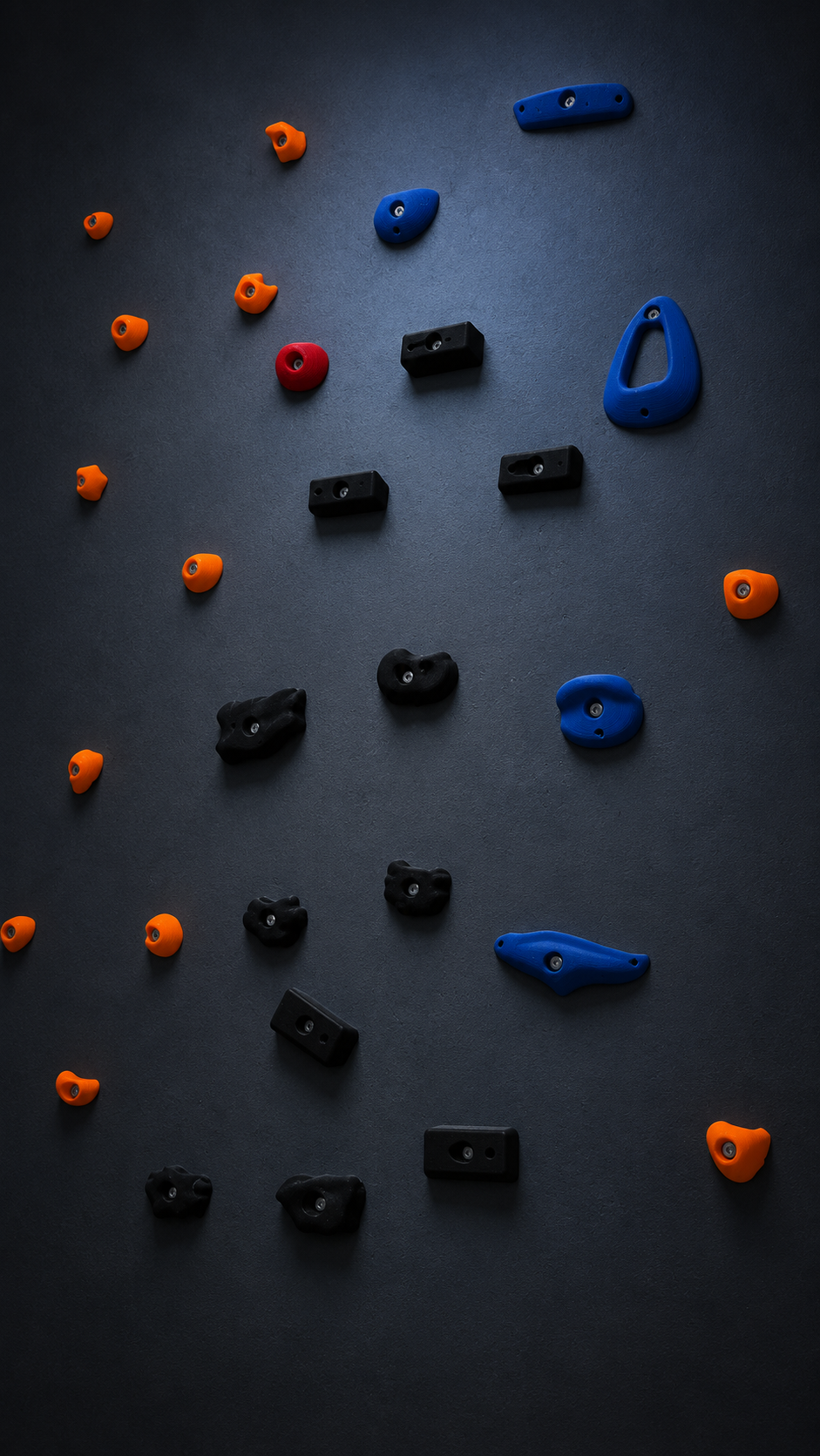 Blaue, orangefarbene, schwarze und rote 3D-gedruckte Griffe an einer dunklen Wand