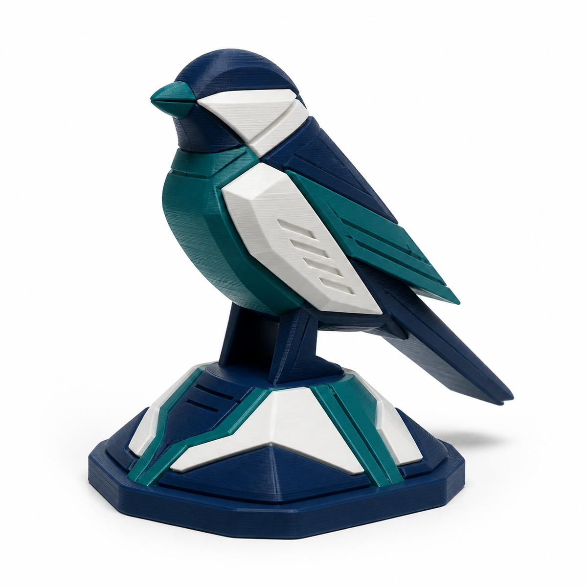 Product illustration of "Geometric bird sculpture in teal and white" on white background: bird sculpture; Basic shape: stylized seated bird figure on polygonal pedestal; Design: angular body, wing and tail surfaces; Colours: teal, dark blue and white.