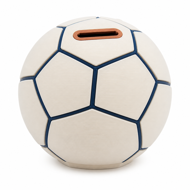 Product image of "Football-shaped money box in cream and dark blue" on white background: money box; Basic shape: a spherical basic shape of clearly structured polygon fields; Design: cream-colored surfaces with dark blue joint lines and a coin slit at the top; Colours: cream, dark blue and copper.