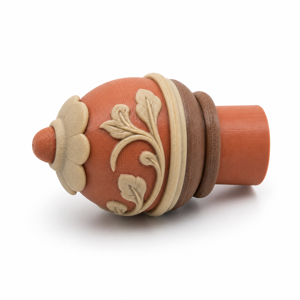 Product illustration by “Cardine bar end piece with leaf stalks” on white background: Curtain bar end piece; Basic shape: conical cone-like closure shape with cylindrical approach; Design: layered ring straps and a flower-shaped front button; Colours: terracotta, beige and brown.