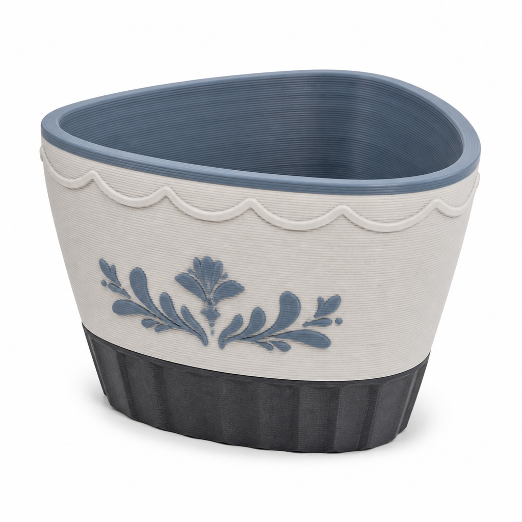 Product image of "Oval plant pot with blue branch motif" on white background: plant pot; Basic shape: wide oval vessel shape with rounded corners and dark foot; Design: a bright smooth front surface and a curved upper ornamental frieze; Colours: white, grey and dark grey.