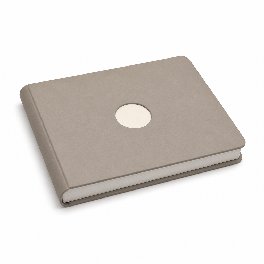 Closed taupe photo album in landscape format with rounded corners, warm white round accent and visible bright side block.
