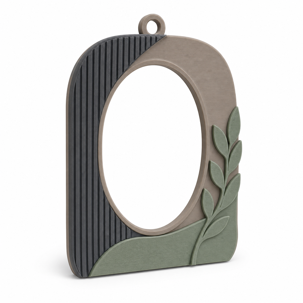 Product illustration of "Oval photo frame with leaf accent" on white background: photo frame; Basic shape: high oval frame with ribbed side surface and upper eyelet; Design: an asymmetrical outer contour and a plastic branch at the front; Colours: taupe, sage green and anthracite.