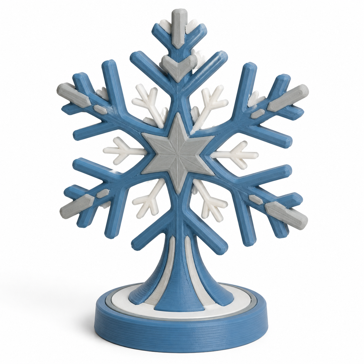 Geometrische Schneeflocke auf Rundsockel – Produktansicht auf weißem Hintergrund; Farben: Blau, Grau und Weiß.