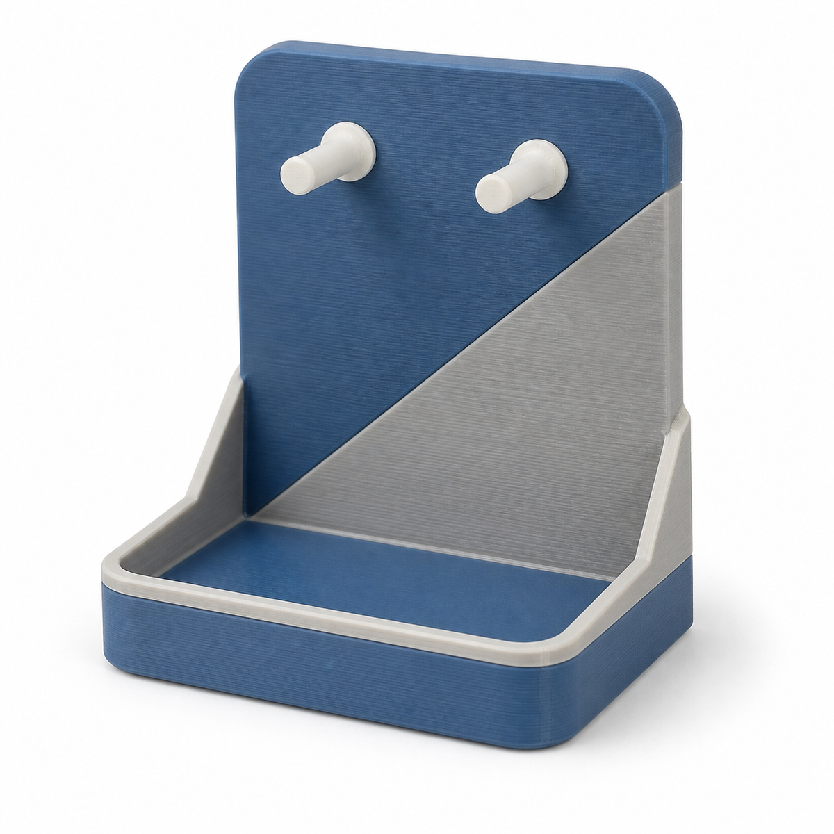Product illustration of "Compact key tray with double hooks" on white background: key tray; Basic shape: rounded rear wall with two white pins over a deep shelf tray; Design: a large diagonal front section and laterally drawn shell edges; Colours: blue, grey and white.