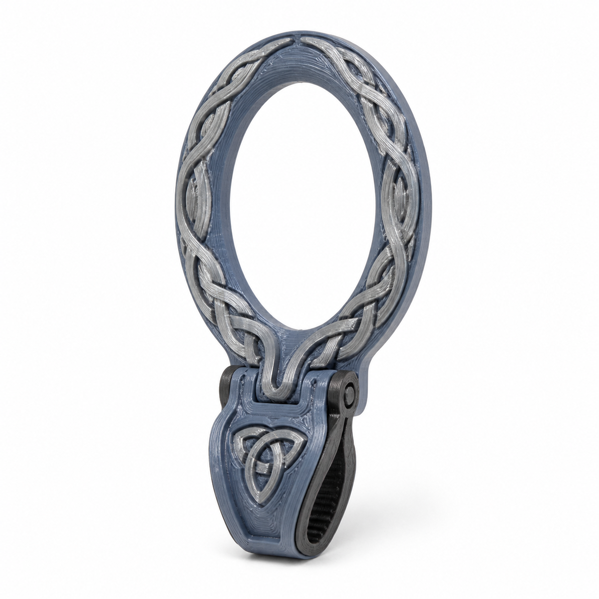 Product illustration of "oval curtain ring with braid clip" on white background: curtain ring; Basic shape: large oval ring shape with attached narrow clip; Design: a circumferential reliefed knot band and a small triquetra motif; Colours: steel blue, silver grey and anthracite.