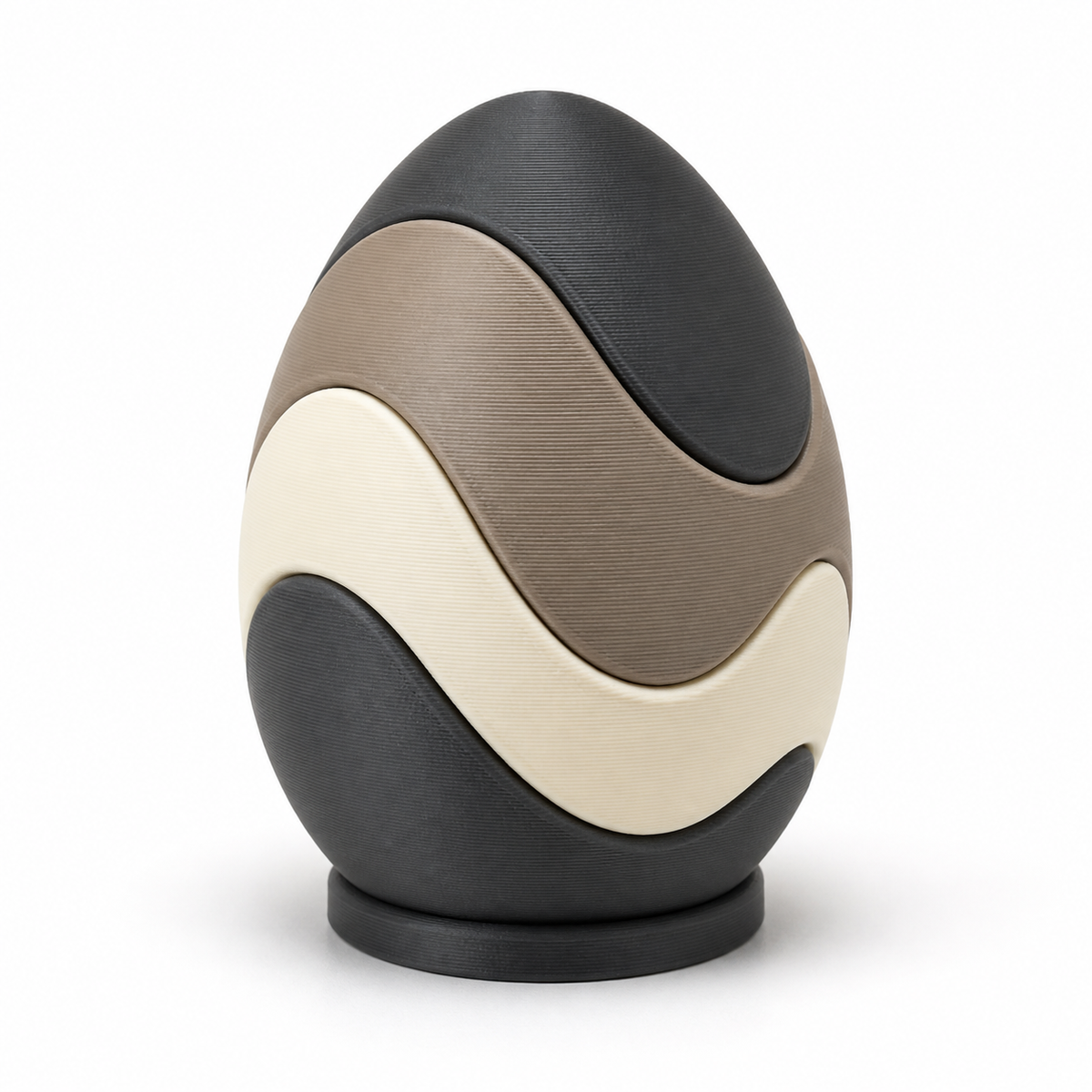 Product image of "Relaxing Easter egg with wavebands" on white background: Easter decoration; Basic shape: upright egg shape on a small dark round base; Design: four wide softly interlocking colour waves; Colours: anthracite, taupe and cream.