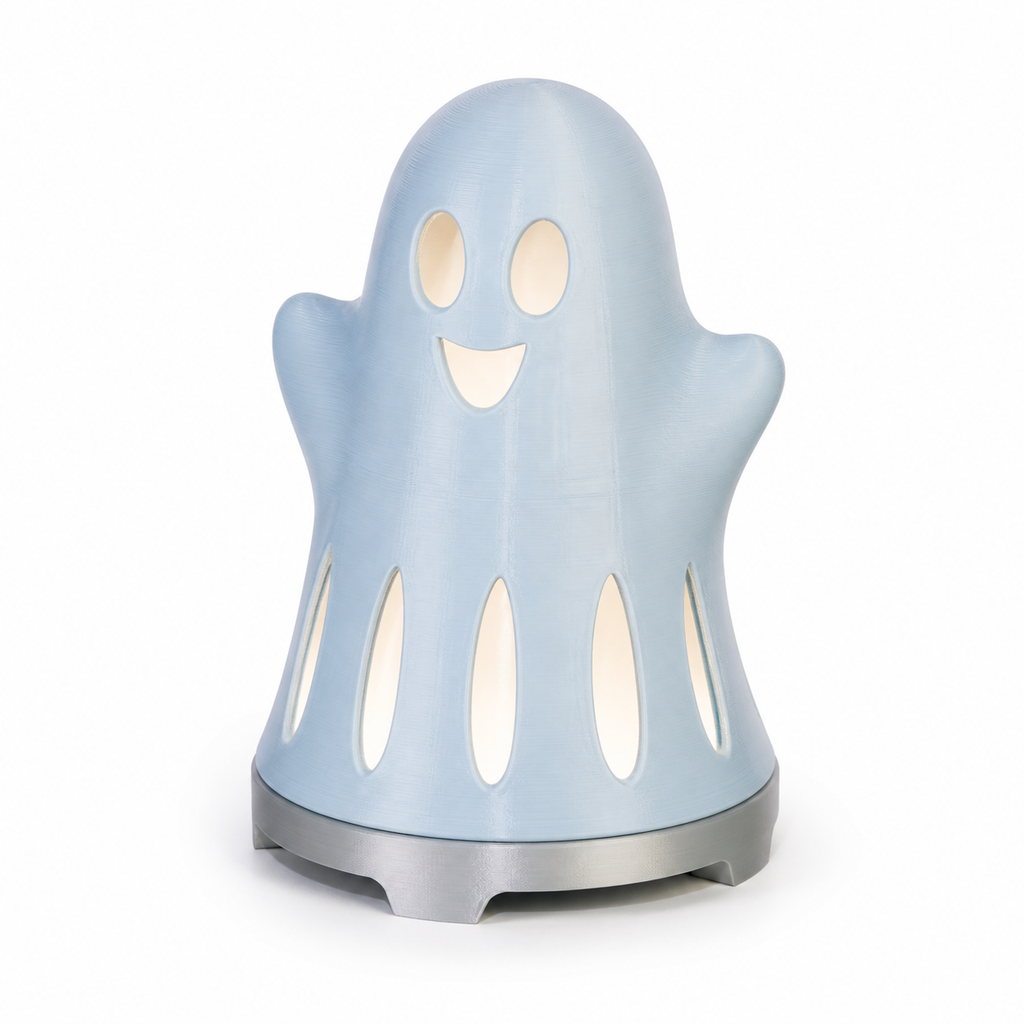 Product illustration of "Friendly Decoration Spirit in Sky blue" on a white background: Halloween decoration; Basic shape: round standing ghost silhouette on a silver-grey round foot; Design: a bright friendly face and several long hem openings; Colours: Sky blue, white and silver grey.