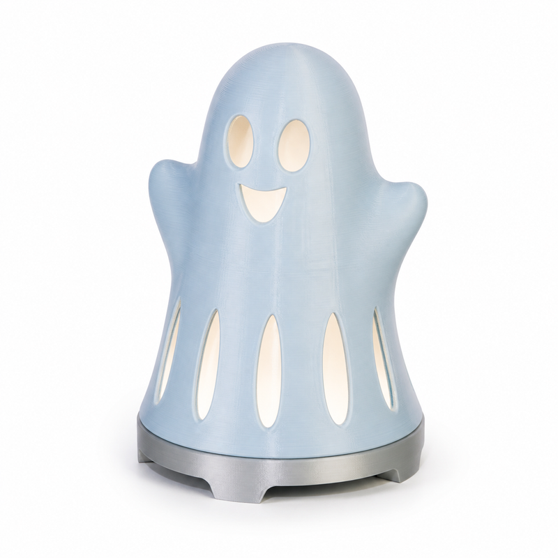 Product illustration of "Friendly Decoration Spirit in Sky blue" on a white background: Halloween decoration; Basic shape: round standing ghost silhouette on a silver-grey round foot; Design: a bright friendly face and several long hem openings; Colours: Sky blue, white and silver grey.