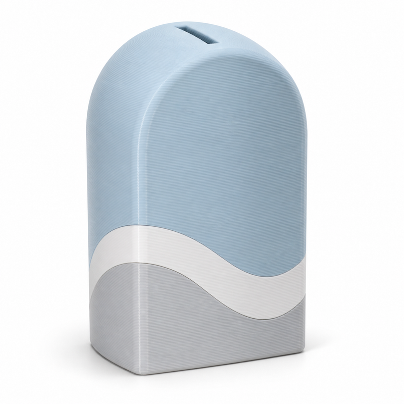 Product image of "Arc-shaped money box in sky blue" on white background: money box; Basic shape: high rounded body with flat stand and upper insertion slot; Design: a soft white waveline over silver-grey base zone; Colours: sky blue, white and silver grey.