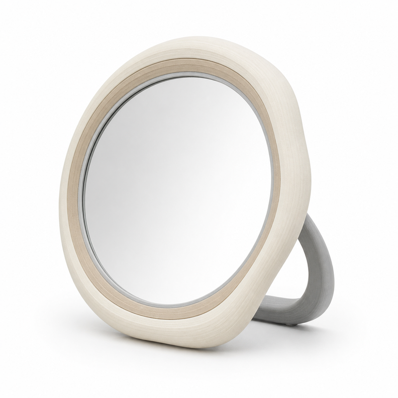 Product image of "round standing mirror in soft natural tones" on white background: standing mirror; Basic shape: round mirror surface in a wide soft frame with back support; Design: several concentric quiet edge bands and a curved foot; Colours: off-white, beige and light grey.