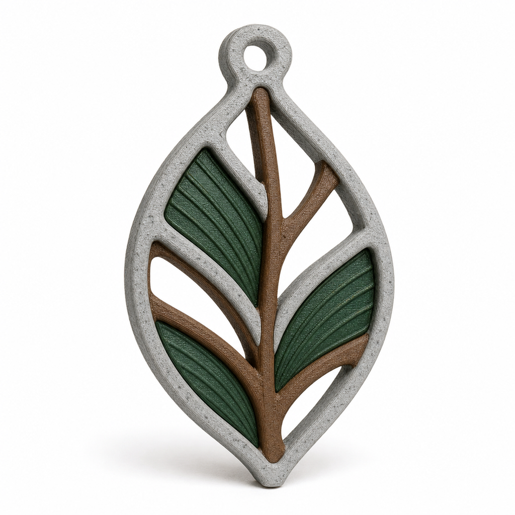 Product illustration of "window ornament in rustic leaf shape" on white background: window ornament; Basic shape: long drawn pointed leaf shape with round upper eyelet; Design: an open mesh of straight curved leaf veins; Colours: stone grey, dark green and brown.