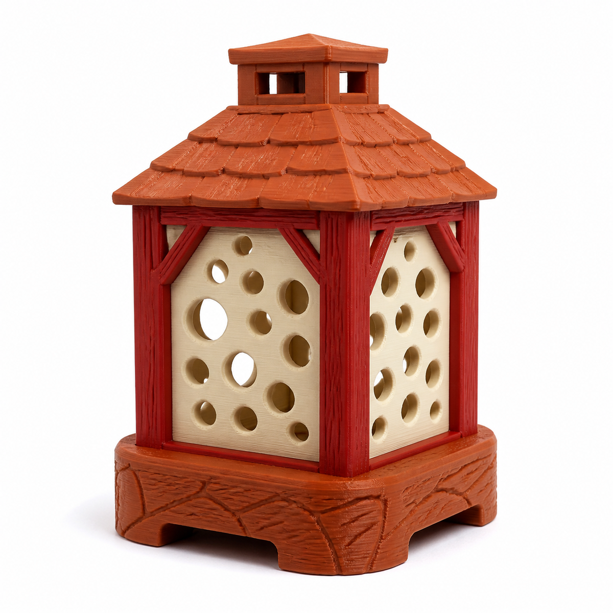 Product illustration of “Rustical garden lantern in terracotta and red” on a white background: garden lantern; Basic shape: rectangular lantern body with layered roof and four short feet; Design: round light openings in creamy panels and reliefed outer strips; Colours: terracotta, red and cream.
