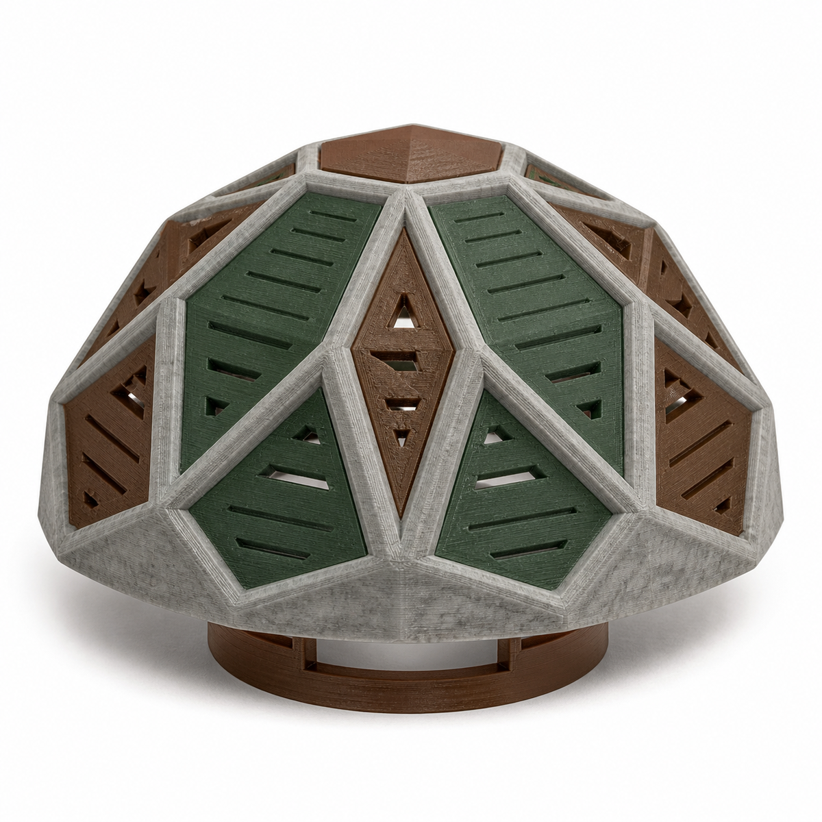 Product illustration of "Facettated lampshade in stone grey and green" on white background: lampshade; Basic shape: wide low dome shape with round lower stand; Design: large triangular panels with ribbed green and brown inner fields; Colours: stone grey, dark green and brown.