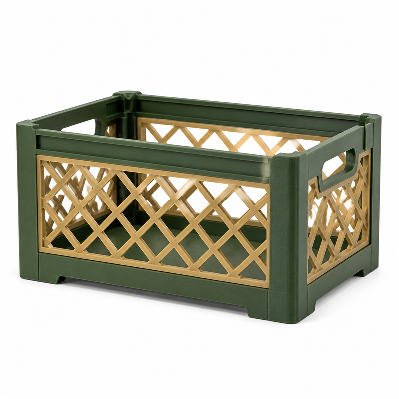 Product illustration of "Gitterbox Emerald gold" on a white background: storage box; Basic shape: open rectangular box with transparent lattice sides; Design: rhodium-shaped braided pattern between dark green frame bars; Colours: dark green, gold and beige.