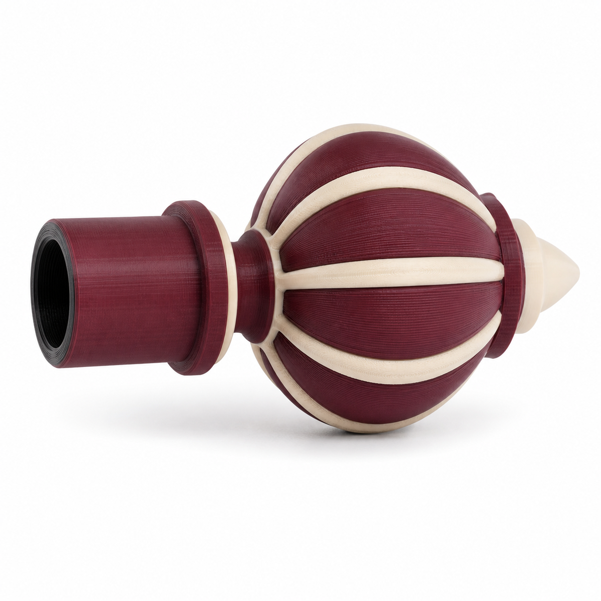 Product image of "Bordeaux curtain end" on white background: curtain bar end; Basic shape: belly-shaped longitudinally ribbed ornamental piece with cylindrical receptacle; Design: symmetrical bud shape with pointed edge; Colours: Bordeaux, cream and black.