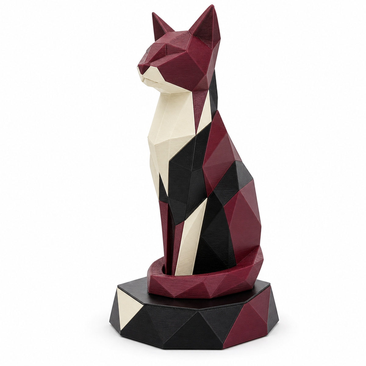 Product illustration of "cat sculpture Bordeaux facet" on white background: decorative sculpture; Basic shape: upright cat sitting on a faceted polygonal pedestal; Design: angular modeled body and facial features with long neck; Colours: Bordeaux, cream and black.